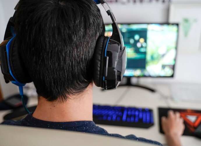 Man wearing headphones sitting in front of a computer